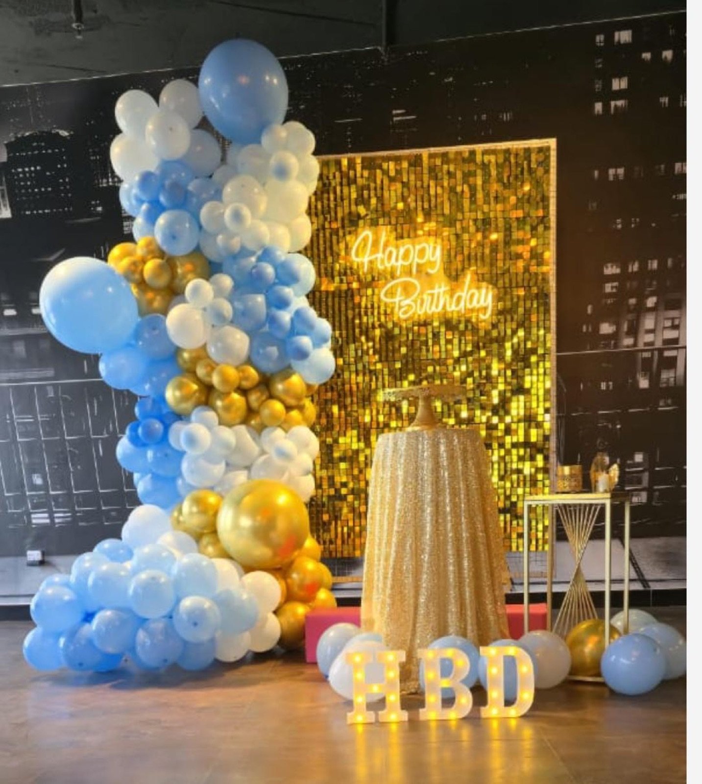 Blue and gold Happy Birthday balloon backdrop with HBD marquee letters