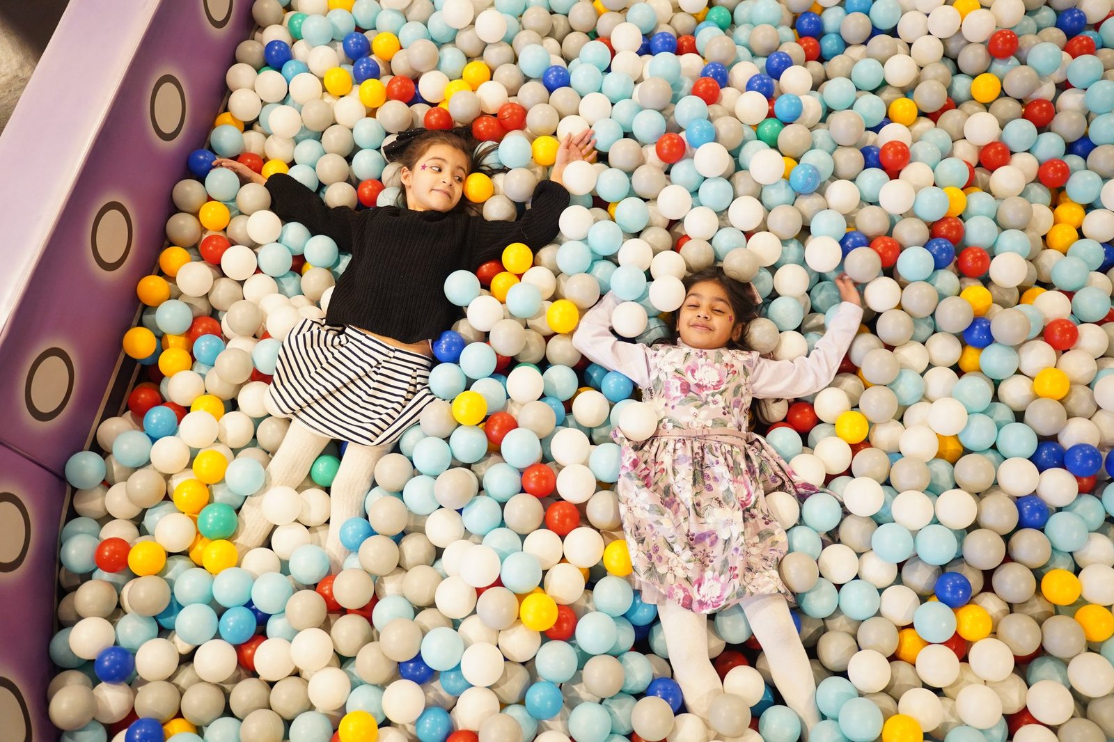 Two girls laughing in the Wonder World ball pit